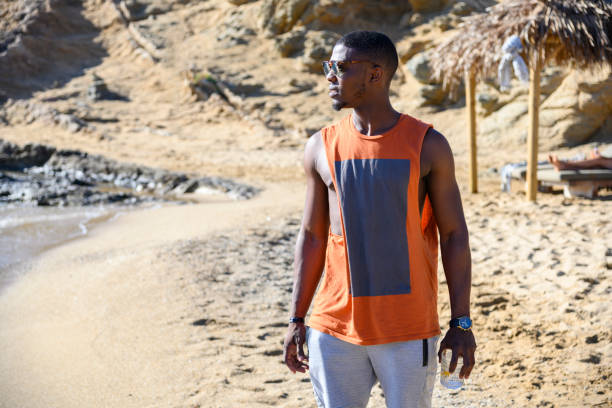 istock African man is standing on the beach 1166853201