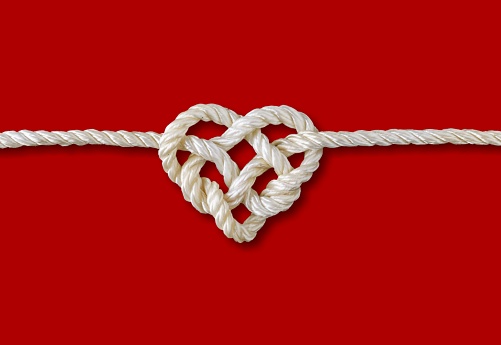 Rope with heart isolated on red background