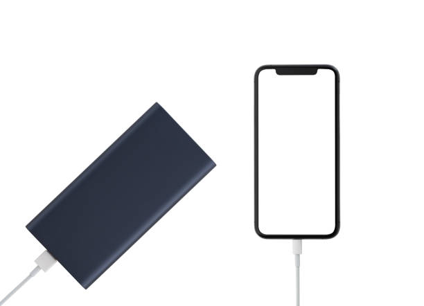 白い背景にパワーバンクとスマートフォン。スマートフォンはパワーバンクから充電中です。 - mobile phone charging power plug adapter ストックフォトと画像