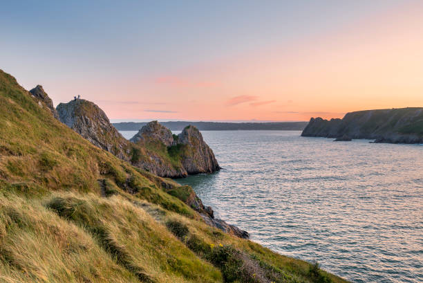 istock Beautiful peaceful Summer evening sunset beach landscape image at Three Cliffs Bay in South Wales 1166858356
