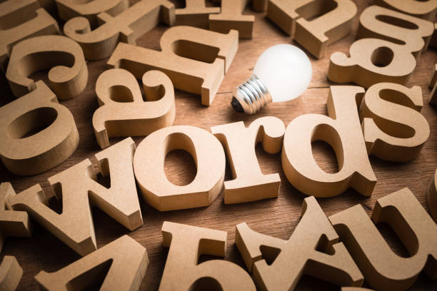 Words Have Power Words alphabets in scettered wood letters on the table with glowing light bulb as communication idea or words have power concept key photos stock pictures, royalty-free photos & images