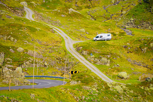 Camper car in green summer norwegian mountains. Travel in motor home, holidays and adventure concept.