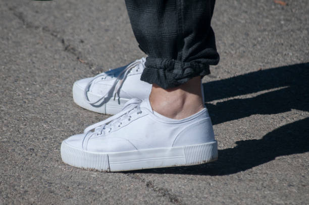 istock Legs in white sneakers 1166863738