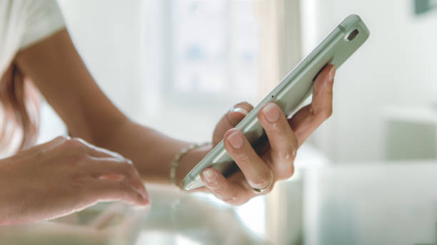 istock Closeup asian hand using smartphone on glass table at beautiful white house. 1166863756
