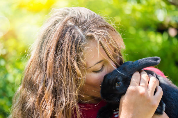 istock young woman hugging her pet rabbit 1166863951