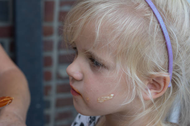 Little girl is sitting at the table for having dinner