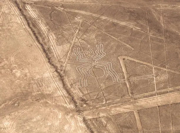 Aerial view of the spider geoglyph drawing in the peruvian coastal desert known as the mysterious Nazca Lines near Nazca city, Peru.