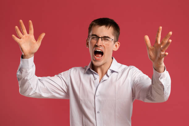 istock Young man in a classic white shirt is posing over a pink background 1166866957