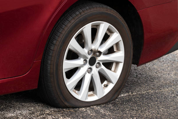 Flat Tire Red car with a flat tire flat tire stock pictures, royalty-free photos & images