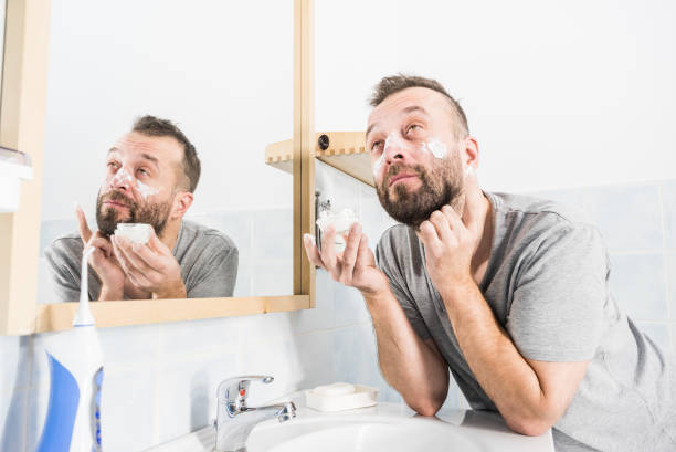 istock Man applying moisturizer cream in bathroom 1166868034