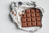 Fragment of chocolate bar in foil close up