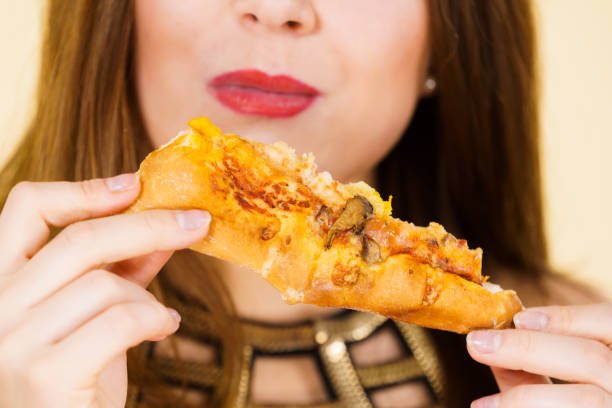 istock Woman eating hot pizza slice 1166869392