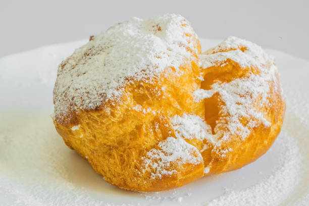 istock Topping profiterole tower with melted dark chocolate close-up. 1166871508