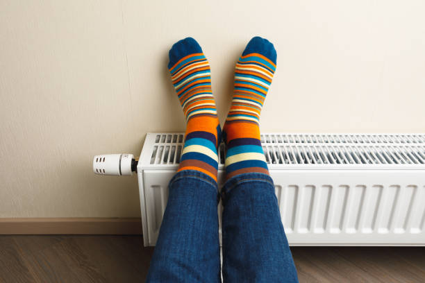 istock legs with colorful socks on heating radiator 1166872420