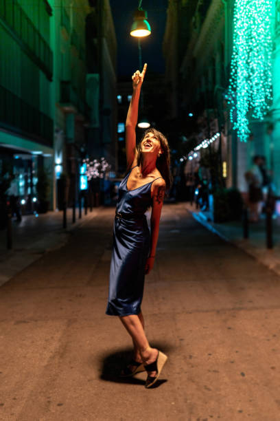 Woman dancing in the middle of the street at night stock photo