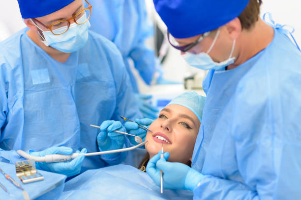 dentista medico e il suo team trattamento di un paziente - usare la bocca foto e immagini stock