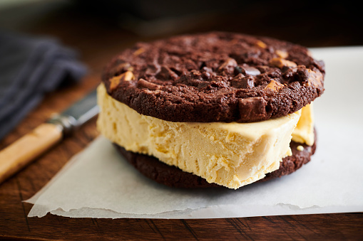 Ice cream sandwich made with dark chocolate cookies and vanilla ice cream.