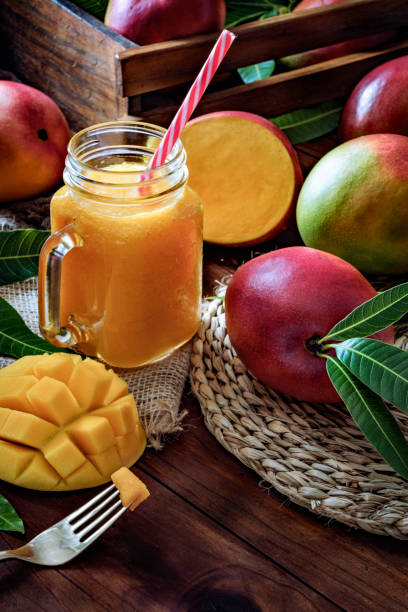 istock Mango smoothie juice and fruit un drinking glass on wooden table in rustic kitchen 1166880732