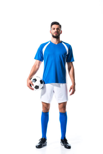 guapo jugador de fútbol en uniforme con pelota aislado en blanco - jugador de fútbol fotografías e imágenes de stock