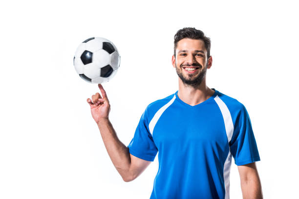 istock smiling handsome soccer player spinning on finger ball Isolated On White 1166881530