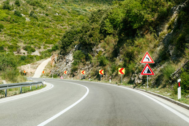 istock Road in the mountains, warning traffic sign 1166881656