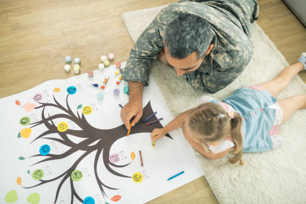 padre e hija tumbados en el suelo y pintando árbol genealógico - árbol genealógico fotografías e imágenes de stock