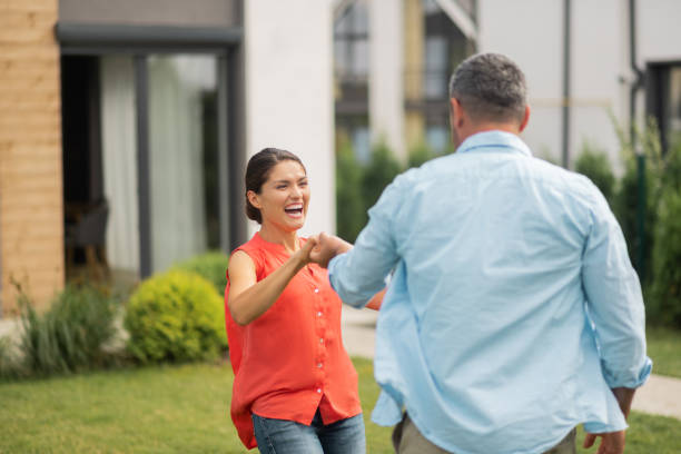 istock Wife laughing while dancing with husband near house 1166882963