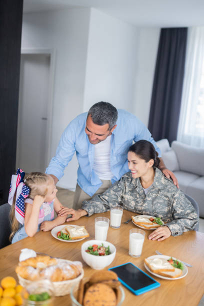 istock Husband hugging his woman serving in armed forces and daughter 1166883672