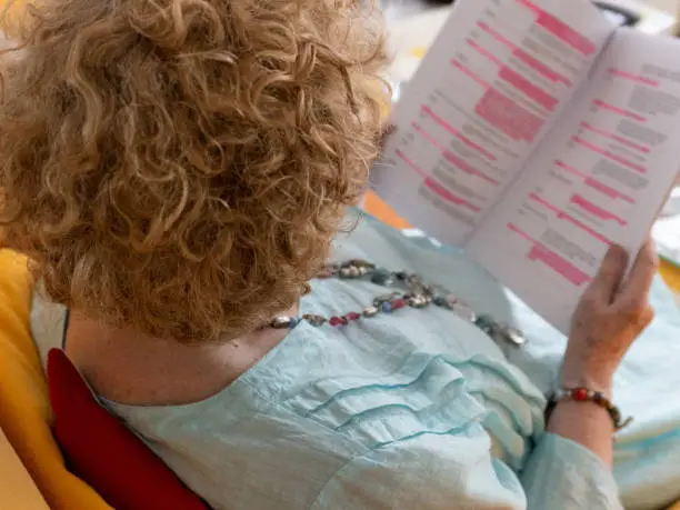 Photo of An actress sitting down, learning her lines from a script