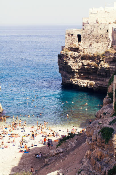 Polignano a Mare, Italy - September 16, 2015: Relaxed people enjoying a summer vacation on the beach in Polignano a Mare, Italy.