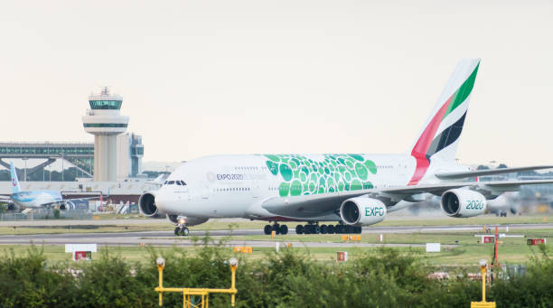 グリーンexpo 2020で装飾されたエミレーツ航空エアバスa380-861は、着陸後に航空管制塔の前で滑走路をオフにします - air traffic control tower airport runway air travel ストックフォトと画像