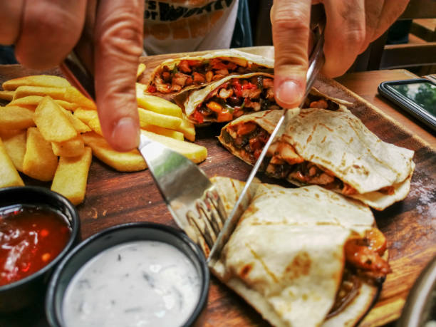 istock chicken quesadilla sliced and eaten by man in a pub 1166890521
