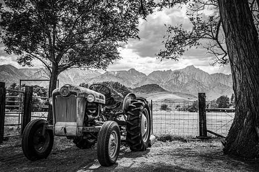 An old tractor sits on a farm near the easter Sierra Nevada mountains.