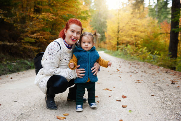 istock Mother holding her daughter on a forest path 1166891432