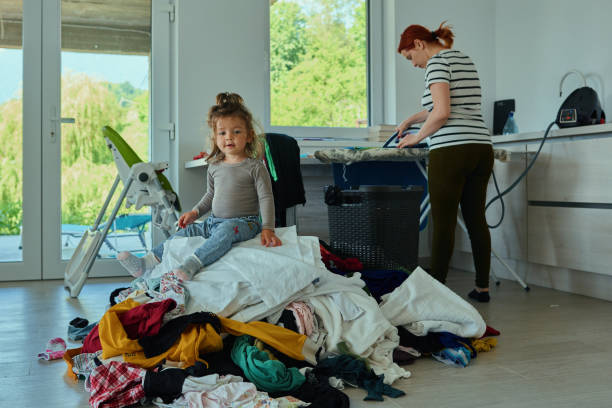 istock Mom ironing and daughter playing 1166891461