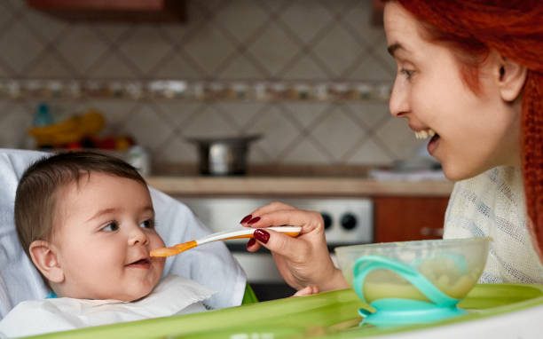 istock Happy mother feeding her little baby 1166891571