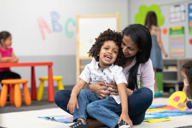 istock Happy preschool student playing with teacher 1166891676