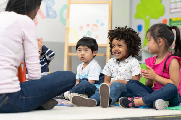 istock Kind female teacher instructing happy group of preschool students 1166891711