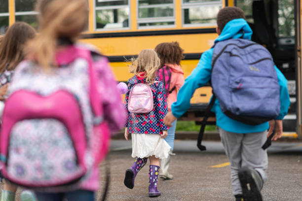 istock Diverse group of happy children getting on school bus 1166891945