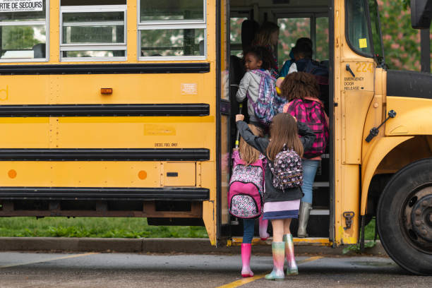istock Diverse group of happy children getting on school bus 1166891951