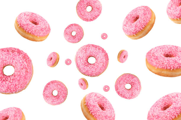 Falling or flying pink glazed doughnuts with sprinkles in motion isolated on white background stock photo