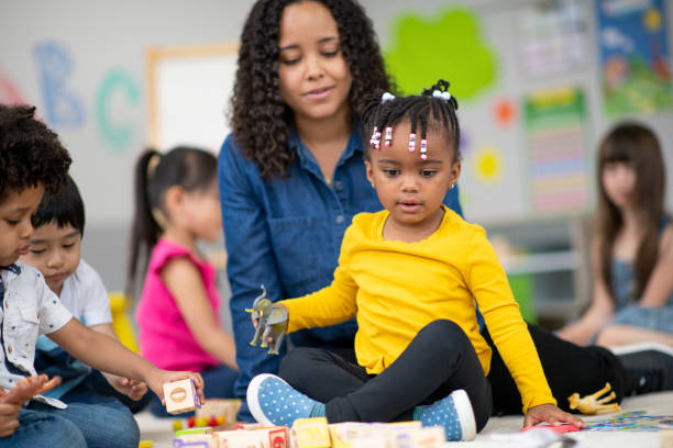 istock Kind female teacher instructing happy preschool students 1166892015