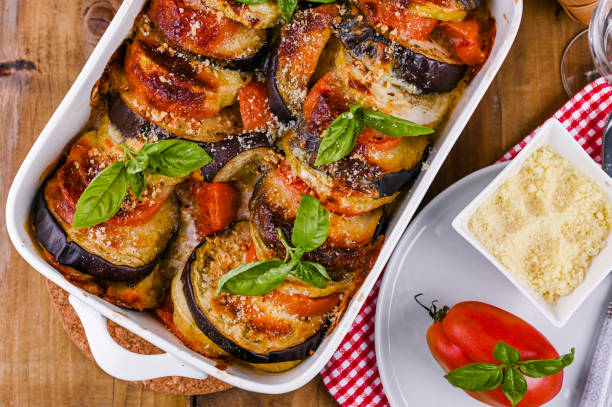 traditionelle italienische küche. eierpflanzen, tomaten mit sauce, parmesan und basilikum. rustikales essen für eine gesunde ernährung. gemüse zum mittagessen. - eggplant stock-fotos und bilder