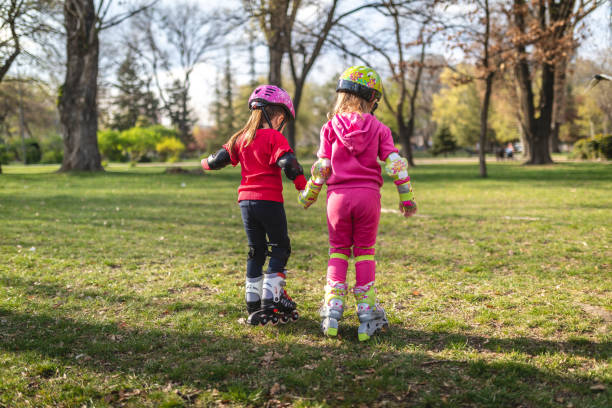 Girl on roller skates. Girl 8-10 years old learning to skate in a summer park