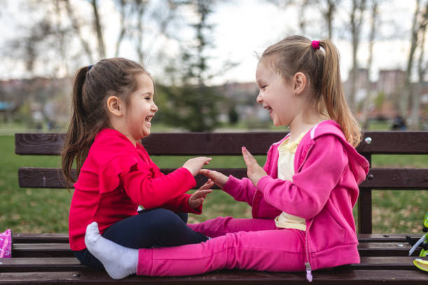 istock Cute children playing together on a park bench 1166894753