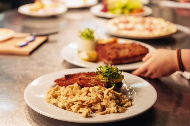 Food orders on the kitchen table in the restaurant, SpÃ¤tzle noodles with Schnitzel, traditional german meal stock photo