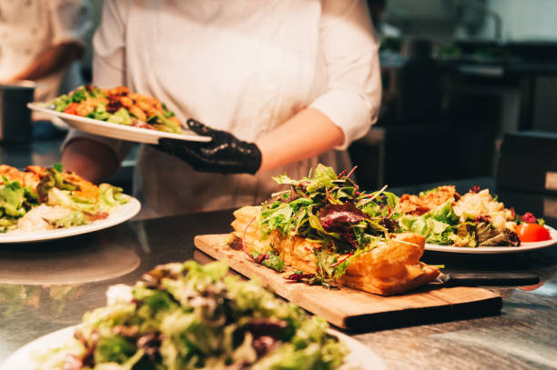 istock Food orders on the kitchen table in the restaurant. Puff pastry base with fresh different kind of green salad on the top 1166898648