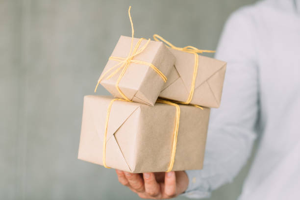 istock corporate birthday party beige gift boxes man hand 1166900424