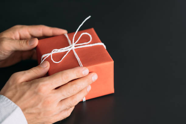 istock corporate birthday party red paper gift box hands 1166900426