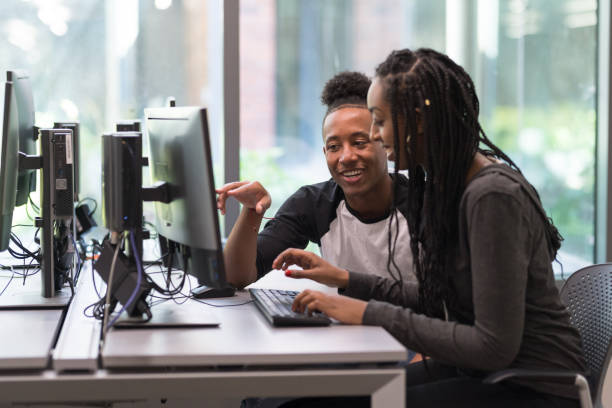 istock College students working at a computer station in the library 1166900891